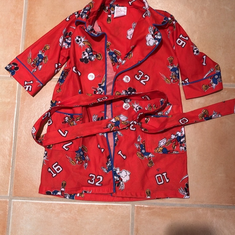 This is a child’s robe. It has a button front, sash, pockets, and a collar.